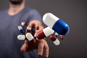 Stock photo of a man reaching for floating pills.  Perfect for healthcare, medicine, and pharmacy.