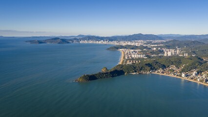 Fototapeta premium Aerial view of Praia Brava in Itajaí with Balneário Camboriú skyline in the background on a sunny day.