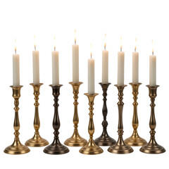 Eight lit white candles in ornate brass and bronze candlesticks burning flame