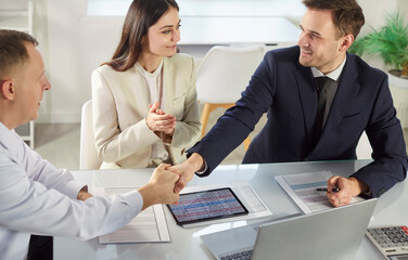 Businessman offers handshake to client or colleague during meeting or conference in office, confirming deal and agreement with teamwork in a professional setting with trust and focus.