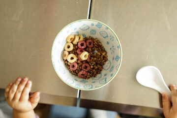 Yummy breakfast cereal in a bowl. Granola and colorful rings.