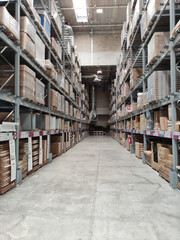 Warehouse interior showcasing tall shelves filled with cardboard boxes, creating a spacious and organized storage environment with ample lighting