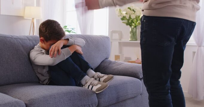 Angry father scolding lecturing sad preschool kid son hiding face for bad school behavior at home, serious parent punishing little upset guilty child boy, demanding discipline during family conflict