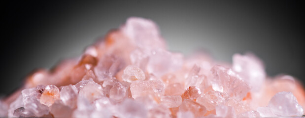 Himalayan salt, pink Himalayan salt crystals closeup. Pink coarse salt crystals macro shot, over black background