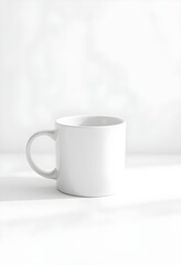 Obraz premium A plain white ceramic mug, handle visible, set against a bright, minimalist background.