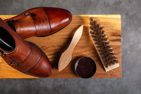 Elegant Leather Shoes with Shoe Care Accessories on Wooden Surface