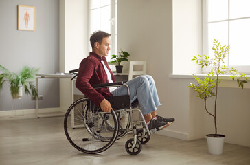 Sad and handicapped man sitting in a wheelchair at home, reflecting on mobility challenges and...