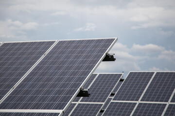 Solar panels installation against cloudy sky renewable energy concept
