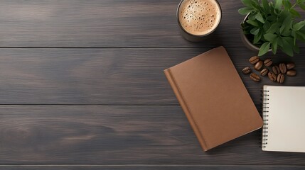 Overhead view of a dark wooden table with a cup of coffee green plant coffee beans and two notebooks