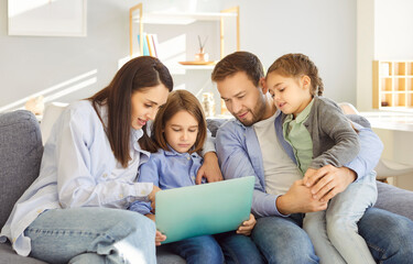 Cheerful happy family watching interesting film online using tablet and high speed internet enjoy weekend together at home sitting on sofa in living room talking on video call with relatives