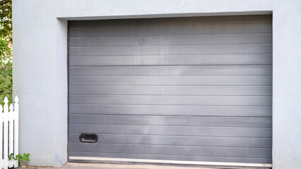 A close-up view of a modern grey garage door, featuring horizontal panels and a sleek, minimalist design.