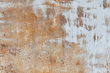A close-up of a textured surface features a weathered mix of rust-orange and white tones