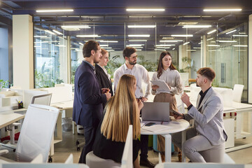 Group of young business people talking about company growth and finance discussing job project with brainstorming on meeting. People employees sitting at the desk in modern office during conference.