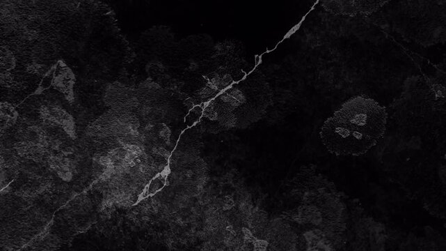 Dark grunge background featuring a bold central crack line and cloudy textures. Ideal for horror themes, cinematic overlays, or moody visual effects.