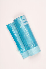A top-down view shows a roll of translucent blue garbage bags