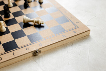 Checkmate. White king chess piece laying down on chessboard after checkmate