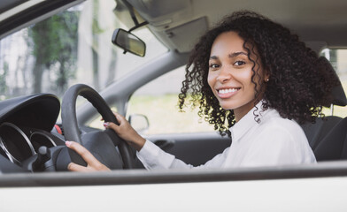 Smiling young woman driving a car. Beautiful businesswoman behind the wheel, transportation, car rental, credit, modern lifestyle, business concept