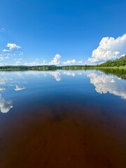 Fototapeta premium Tranquil Lake with Reflections and Blue Sky – Peaceful Nature Scene