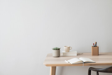 Fototapeta na wymiar Minimal Scandi interior. Wooden table, vase, white book and coffee cup. Soft natural light, calm cozy atmosphere. Home office. Empty gray wall background