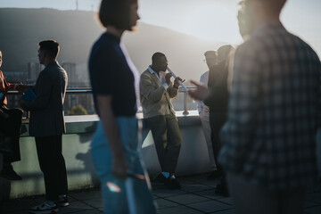 Diverse business people engage in a brainstorming session on a rooftop balcony at sunset. The group...