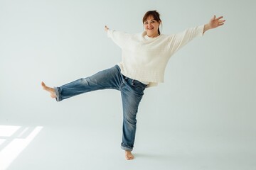 Happy mature woman dancing barefoot and smiling, celebrating wellness and body positivity