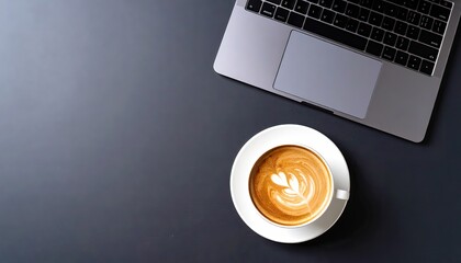 Latte art coffee next to a laptop on a desk