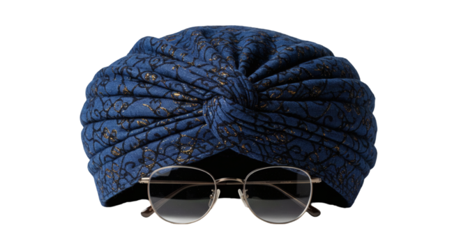 Blue patterned turban and eyeglasses against a black background.