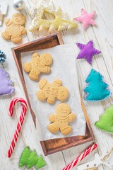 Christmas gingerbread cookies in the shape of a snowman on a white wooden background. Christmas decorations. Top view, flat lay.