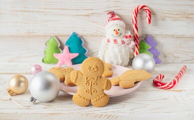 Christmas gingerbread cookies in the shape of a snowman on a white wooden background. Christmas decorations.