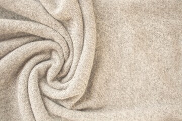 Cashmere beige fabric, top view. Draped, texture, background. Natural wool clothing.