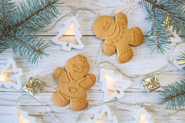 Christmas gingerbread cookies in the shape of a snowman on a white wooden background. Christmas decorations. Top view, flat lay.
