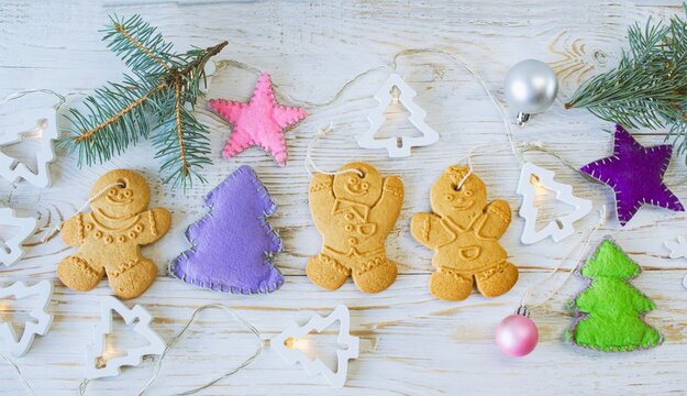 Christmas gingerbread cookies in the shape of a snowman on a white wooden background. Christmas decorations. Top view, flat lay.