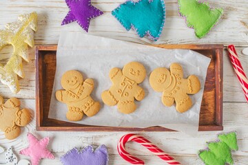Christmas gingerbread cookies in the shape of a snowman on a white wooden background. Christmas decorations. Top view, flat lay.