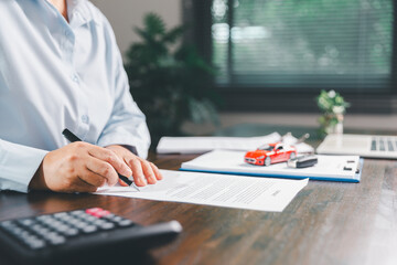 Customer signing insurance document lease agreement table, writing signature contract buying...