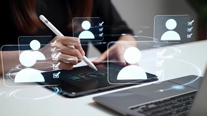Woman in Black Using Digital Tablet with Futuristic Interface on White Desk With a Laptop Nearby