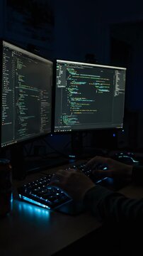 Coding session in dark room with dual monitors showcasing programming tasks at night
