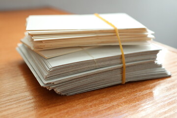 A Neatly Arranged Stack of Blank Cards Securely Tied with a Rubber Band on a Wooden Table