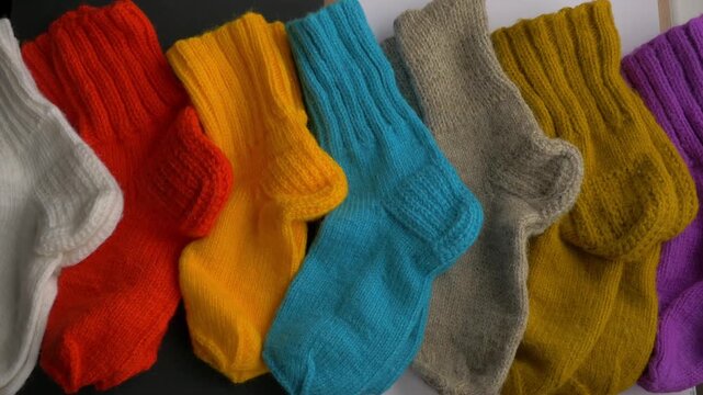 Colorful knitted socks displayed in a vibrant arrangement, showcasing texture and design, camera pans across the collection for dynamic view . selection assortment