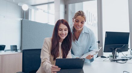 Two Professional Women Engaging in Collaboration Within a Contemporary Office Environment