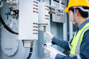 Engineer is working at power substation performing high voltage inspection to check infrastructure...