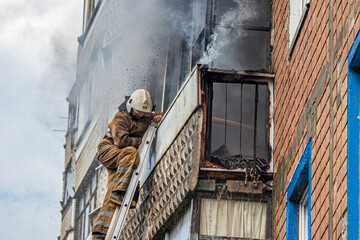 Firefighter extinguishing balcony fire of apartment building
