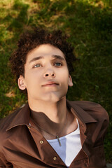 Stylish young man enjoys a sunny afternoon in a lush green park