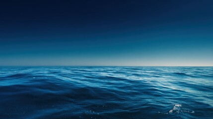 Serene ocean view showcases deep blue water meeting the horizon under a clear sky, perfect for travel, nature, or relaxation themed projects and designs.