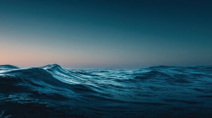 Ocean waves ripple across the water's surface, creating a dynamic seascape with varying shades of blue and hints of sunlight reflecting off the crests, evoking a sense of tranquility.
