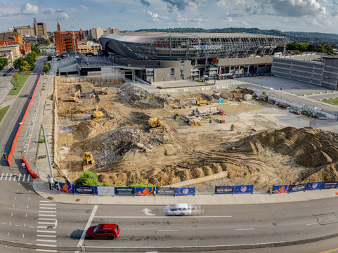 Cincinnati, United States - 18 July 2025: Aerial view of earth movers reshaping the landscape near the stadium, a symphony of urban transformation.