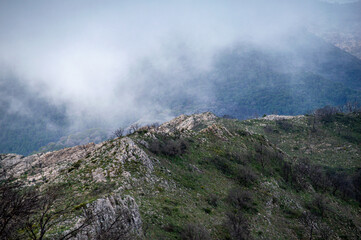 Hiking on trail along abandoned open-pit mine and burnt trees near Mijas, Spain 