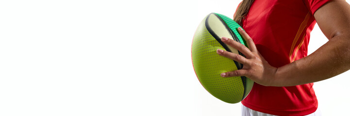 Woman holding rugby ball in front of her, in red jersey against white background. Concept of detail...