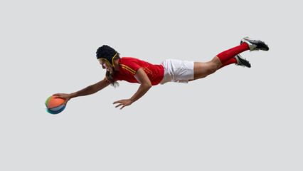 A female rugby player scores by performing a leap in mid-air. Concept of dramatic dive, commitment to win, isolated power