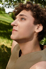 Young man enjoys summer in green park showcasing stylish seasonal fashion