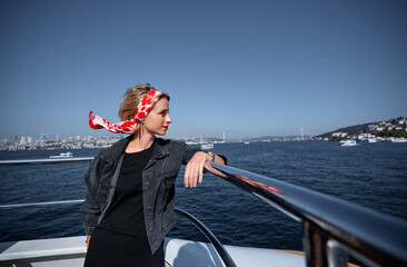 Elegant Woman Relaxing on a Boat with Scenic City and Ocean Views